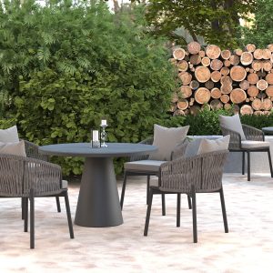 Pure Round Table with four gray chairs, outdoor setting with wood pile